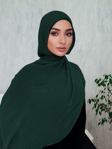 Woman wearing a dark green premium modal hijab with matching jersey undercap — Ayesha's Collection