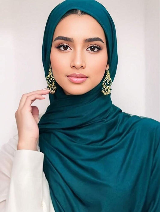 A woman wearing a teal blue rayon cotton jersey scarf.