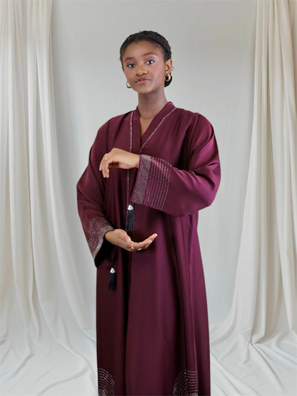 Woman wearing a burgundy abaya Embellished with rhinestone