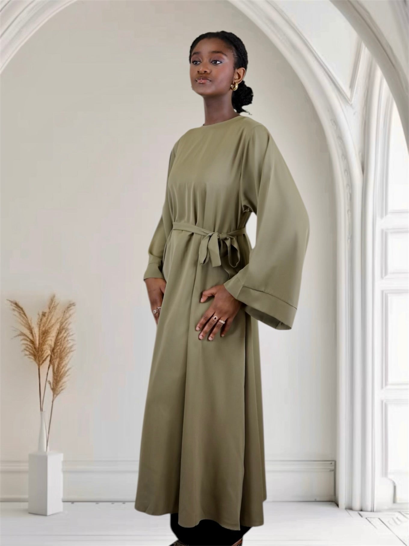 Woman wearing a long sage green abaya dress