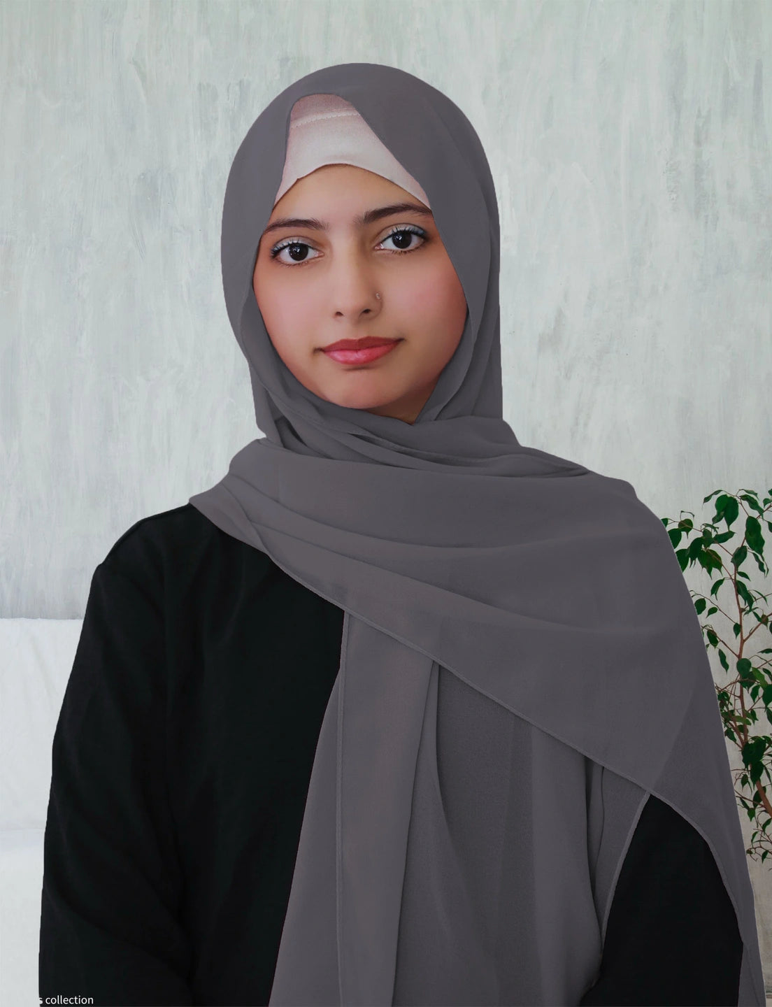 A woman wearing a dusty blue chiffon hijab with a long rectangle shape.