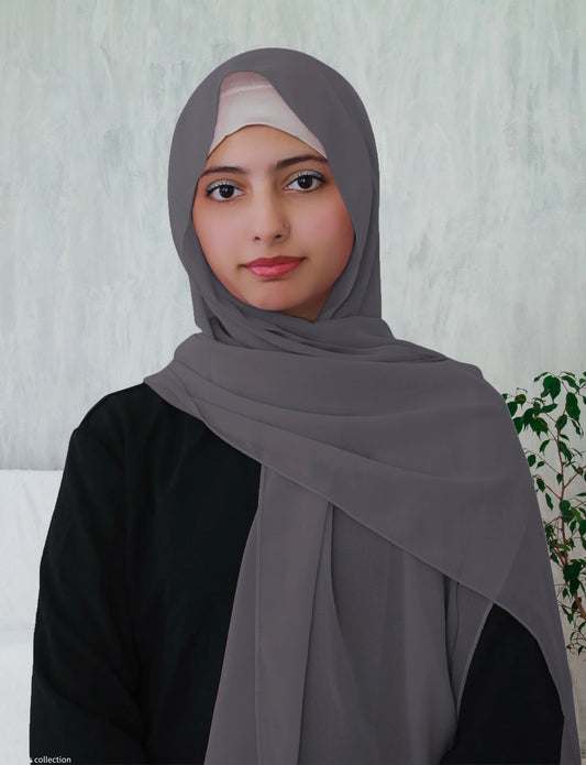 A woman wearing a dusty blue chiffon hijab with a long rectangle shape.