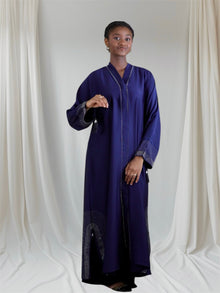 Woman wearing a long, dark blue abaya dress