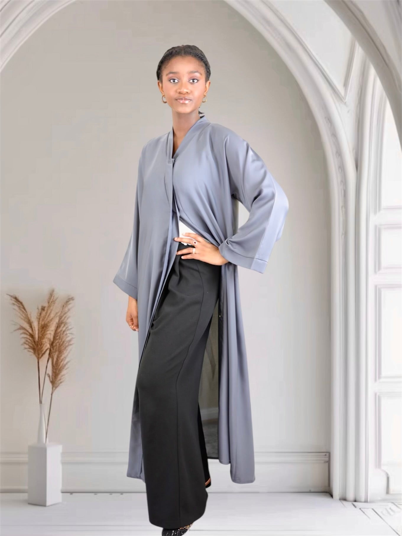 Woman wearing a long, light gray abaya dress