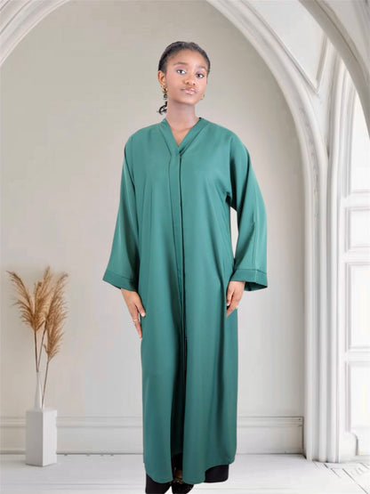 Woman wearing a long green abaya dress