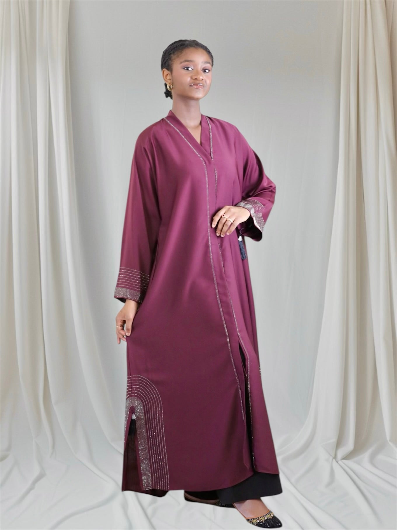 Woman wearing a long burgundy dress with intricate patterns